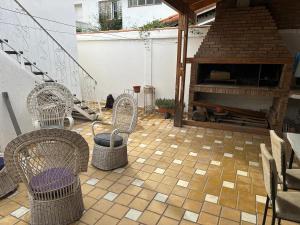 a patio with three wicker chairs and a piano at CASA PATRICIAS in Godoy Cruz