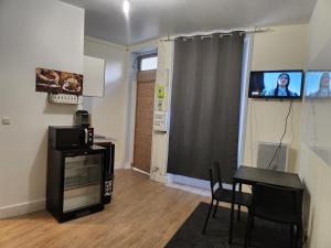 een woonkamer met een tafel en een tv aan de muur bij Charmant studio spacieux paris in Parijs