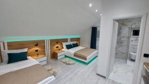 a hotel room with two beds and a shower at Premier House by RD Group in Korenica