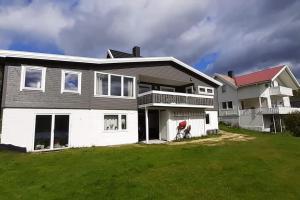 una casa grande con un césped verde delante de ella en Nice house with a great view! en Skjervøy