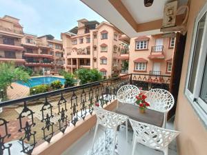 卡兰古特Pool facing luxury 1bhk near Calangute,baga beach的阳台配有桌椅,享有建筑的景致。