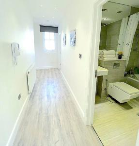 een witte badkamer met een wastafel en een toilet bij Harrow Apartments in Londen