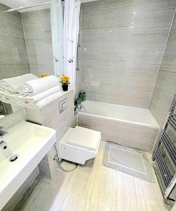 倫敦的住宿－Harrow Apartments，带浴缸、卫生间和盥洗盆的浴室