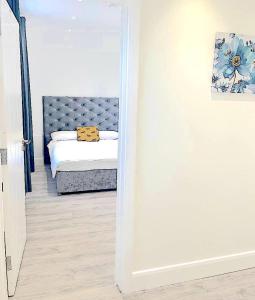 een slaapkamer met een bed in een kamer met een spiegel bij Harrow Apartments in Londen