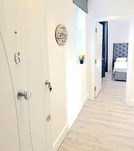 een kamer met een gang met een bed en een deur bij Harrow Apartments in Londen