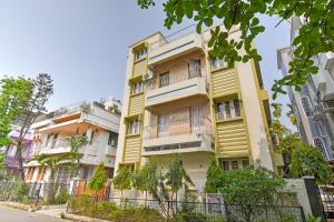 um edifício amarelo com varandas numa rua em Hotel Dreamy Sunshine em kolkata