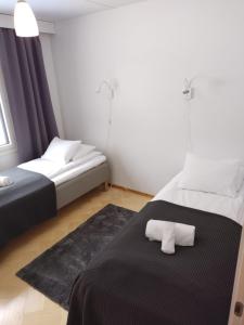 1 dormitorio con 2 camas y manta negra en Asuntos-1, en Lahti