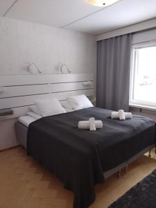 ein Schlafzimmer mit einem großen Bett mit zwei Handtüchern darauf in der Unterkunft Asuntos-1 in Lahti