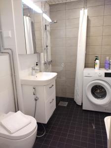 ein Badezimmer mit einem Waschbecken und einer Waschmaschine in der Unterkunft Asuntos-1 in Lahti
