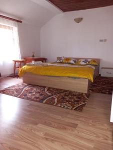 a bedroom with a bed and a rug on the floor at La Marian pensiune restaurant in Munună +15 photos