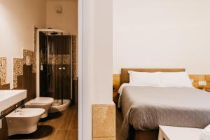 a bathroom with a bed and a toilet and a sink at Le Contrade Vico Alba in Monopoli +89 photos