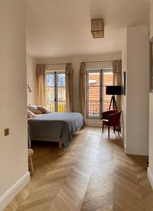 - une chambre avec un lit, une chaise et des fenêtres dans l'établissement Grande maison hyper centre Versailles, à Versailles