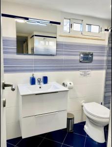 Un baño con un lavabo blanco y un inodoro. en La Caletta Casa Vacanze, PRIVATE POOL, en Terrasini