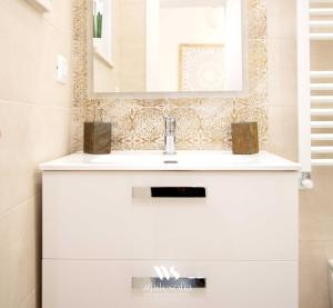 y baño con lavabo blanco y espejo. en WHITE SOFIA - uno sguardo sul mare, en Bari