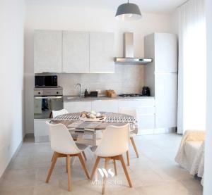 a kitchen with a table and chairs in a room at WHITE SOFIA - uno sguardo sul mare in Bari