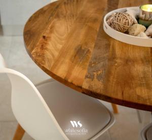 a wooden table with two white chairs and a bowl of food at WHITE SOFIA - uno sguardo sul mare in Bari +28 photos