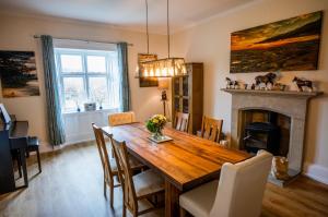 a dining room with a wooden table and a fireplace at Abbey Farmhouse 