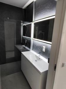 a bathroom with a white sink and a mirror at Apartament Jak w banku in Kłodzko