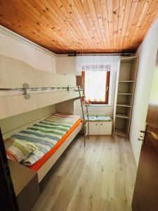 a bedroom with a bunk bed with a wooden ceiling at Apartma Lip in Rateče