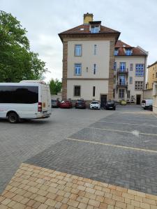 a white van parked in a parking lot in front of a building at Apartament Jak w banku in Kłodzko