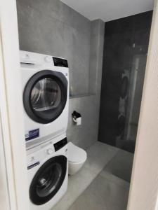 a bathroom with a washing machine and a toilet at Apartament Jak w banku in Kłodzko