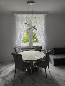 a dining room with a table and chairs and a window at Apartament Jak w banku in Kłodzko