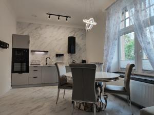 a kitchen and dining room with a table and chairs at Apartament Jak w banku in Kłodzko