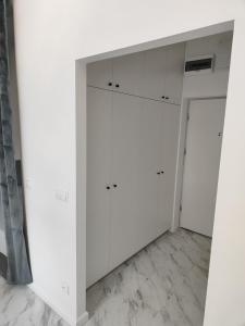 a white closet with white cabinets and a door at Apartament Jak w banku in Kłodzko