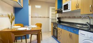 a small kitchen with a wooden table and a sink at Encantador Apartamento con Wifi en Sestao in Sestao