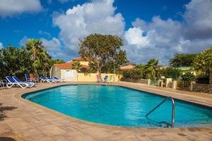 a swimming pool in a resort with blue chairs at 21 Villa Chuchubi in Kralendijk