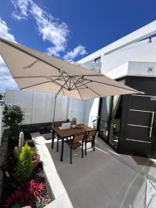 - une terrasse avec une table et un grand parasol dans l'établissement Papá Totë Deluxe, à Playa Honda