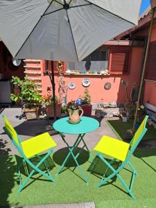 un tavolo e due sedie e un ombrellone di Casa Susy a Roma