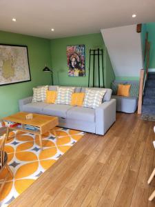 a living room with a couch and a table at Forest Cedar Lodge, Forest of Dean in Cinderford