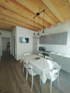 a kitchen with a white table and white chairs at Parsifal House in Chioggia +45 photos