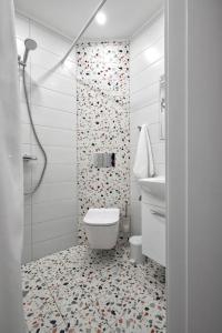 a white bathroom with a toilet and a shower at Sea Moreto Apartment 2 in Burgas City