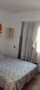 una camera da letto con un letto e una finestra di quarto com banheiro privativo a Florianópolis