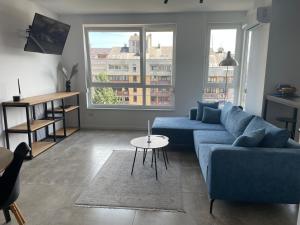 バニャ・ルカにあるAlex apartmentの青いソファとテーブルのあるリビングルーム