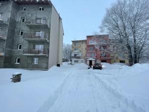 una calle cubierta de nieve frente a un edificio en Muntele Semenic, en Semenic