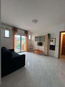 a living room with a black couch and a table at Appartamento Sud Sardegna, Cagliari Elesar'sHome in Capoterra