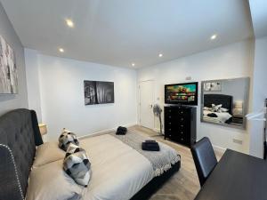 a bedroom with a bed and a table and a tv at Elegant Large Room in Beckenham