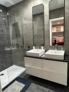 ein Bad mit 2 Waschbecken und einer Dusche in der Unterkunft Spacious Luxury 3 bedroom apartment - Southridge - Mellieha in Mellieħa