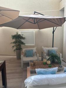 eine Terrasse mit einem Tisch und einem Sonnenschirm in der Unterkunft Spacious Luxury 3 bedroom apartment - Southridge - Mellieha in Mellieħa