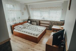 a bedroom with a bed and a tv in it at Willa Baca in Duszniki Zdrój