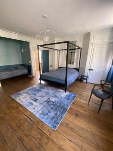 a bedroom with a bed and a rug on a wooden floor at VICTOR HUGO in Amiens