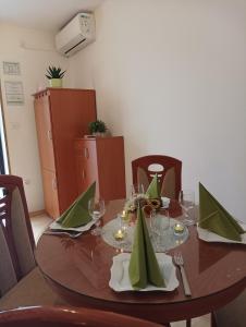 Apartment Milotić في لوفران: طاولة عليها مناديل خضراء وكؤوس للنبيذ