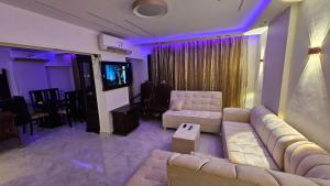 a living room with a couch and a television at shiraton Cairo Airport appartement in Cairo