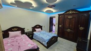 a bedroom with two beds and a dresser at shiraton Cairo Airport appartement in Cairo