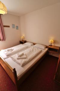 a bedroom with two beds with white sheets and two lamps at Apartment 03 - Ferienresidenz Roseneck, mit Schwimmbad in Todtnauberg bei Feldberg in Todtnauberg +19 photos