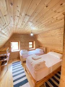 a bedroom with two beds in a wooden cabin at Rupa Guest House in Theth