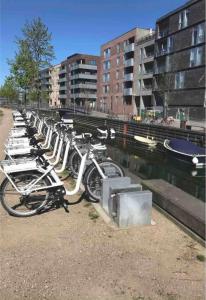 a row of bikes parked next to a river at Canal view In City in Copenhagen